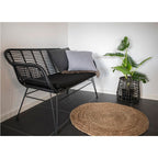 Tapis Bombay jute Ø90 cm ambiance salon banc rotin noir et plante monstera