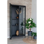 Tapis Bombay jute Ø90 cm ambiance vitrine métal noir et plantes magnolia intérieur moderne