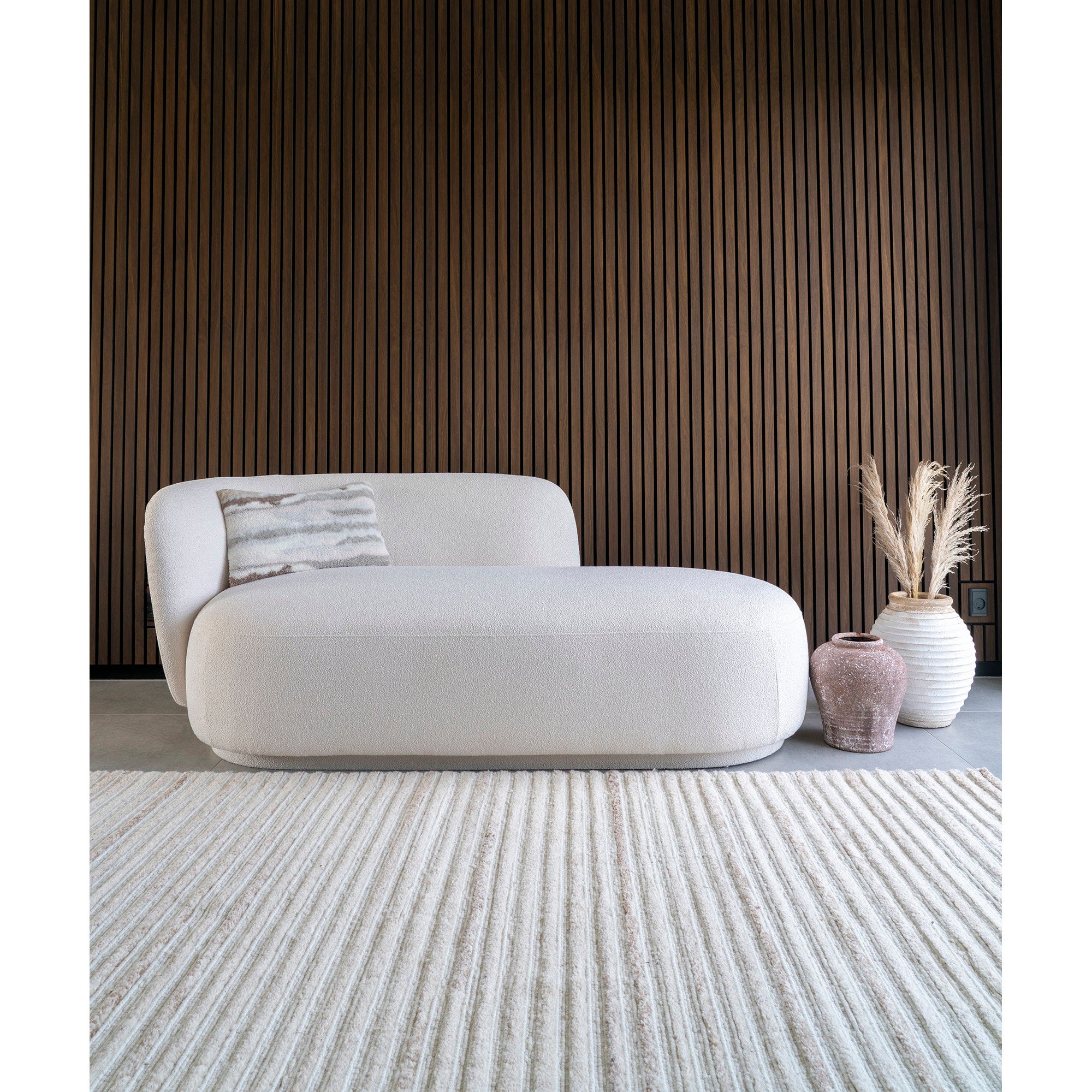 Tapis Mango laine ivoire ambiance canapé bouclette blanc salon mur bois
