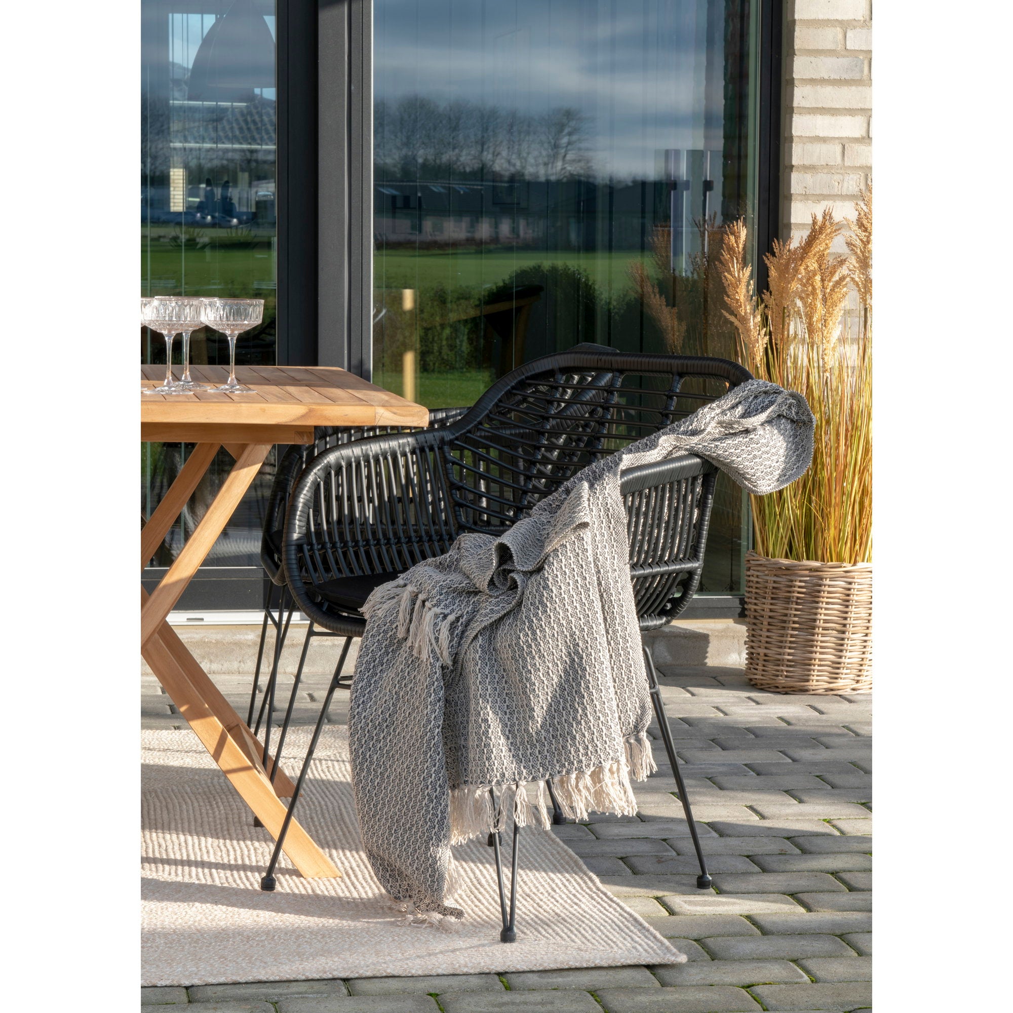 Tapis Menorca sable terrasse table teck chaises corde noire décoration extérieur