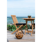 Terrarium San Marino posé sur une table pliante en teck sur une terrasse face à la mer