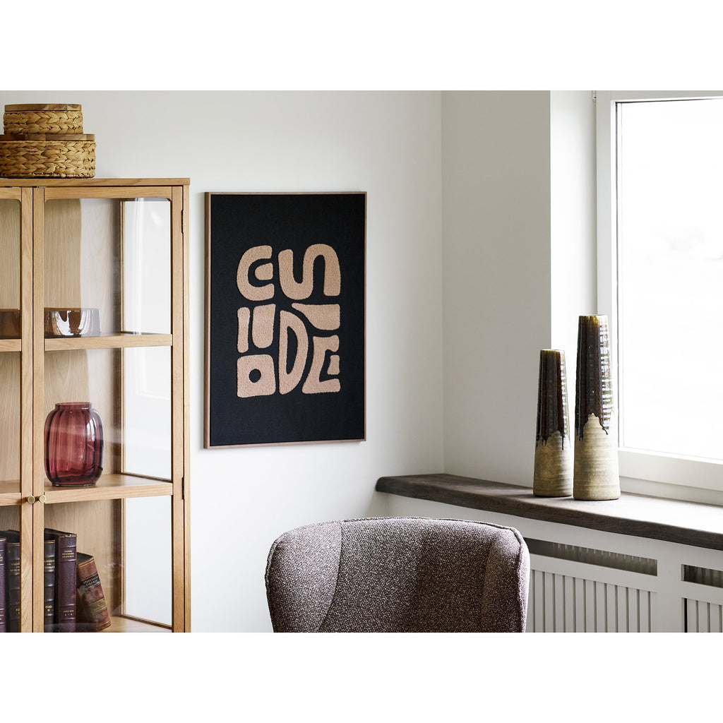 Vase céramique effilé brun tabac posé sur rebord fenêtre salon avec vitrine chêne