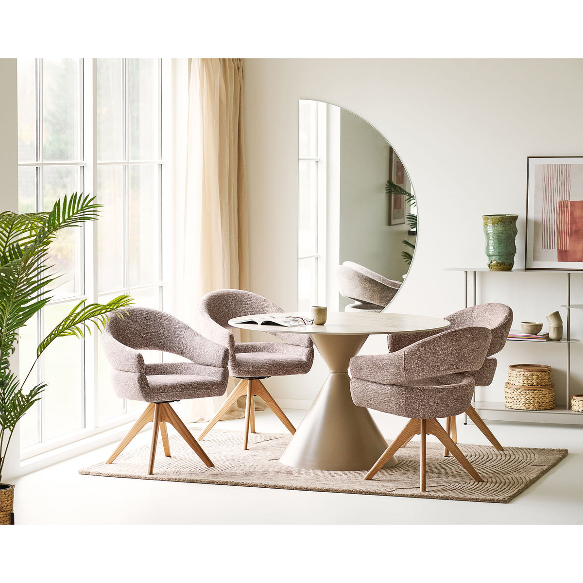 Vase céramique vert posé sur une étagère beige au fond d'une salle à manger avec fauteuils pivotants