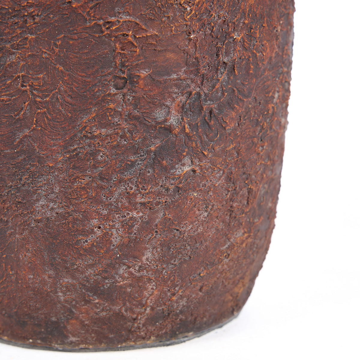 Gros plan sur la surface texturée et la base du vase Clay Echo en terre cuite bordeaux