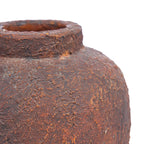 Gros plan sur le relief de la terre cuite bordeaux aux reflets rouille du vase Clay Echo