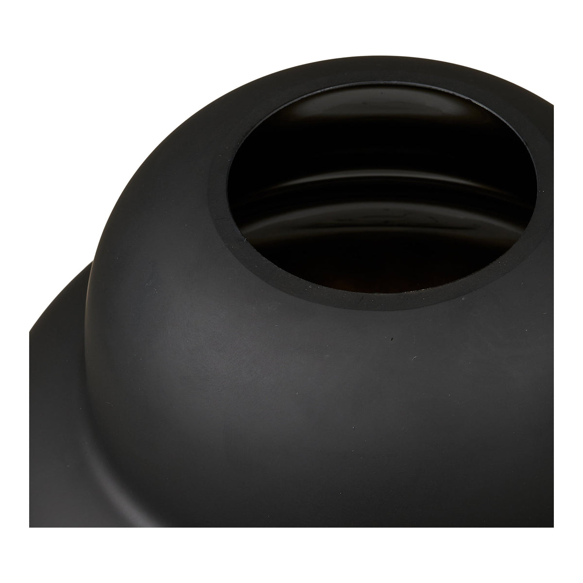 Gros plan sur l'ouverture du vase noir mat et son intérieur en verre brillant
