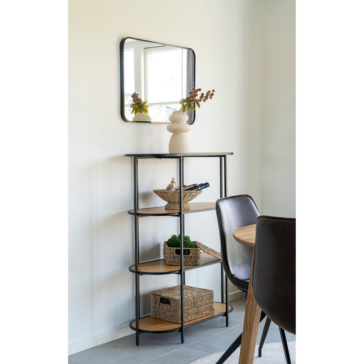 Vase totem en grès beige sur une étagère en métal noir et bois clair sous un miroir