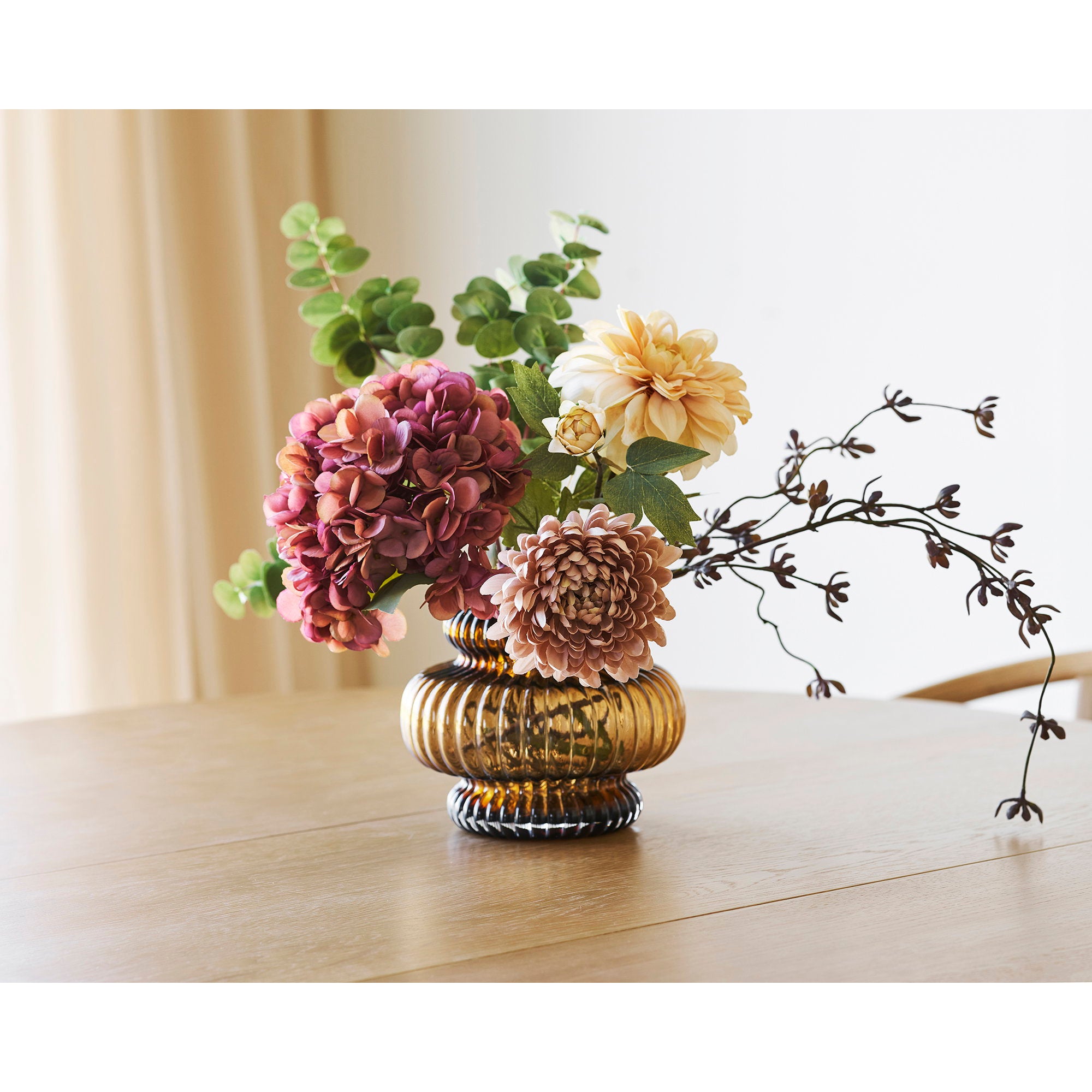 Vase verre ambré soufflé bouche avec bouquet fleurs fraîches sur table en bois