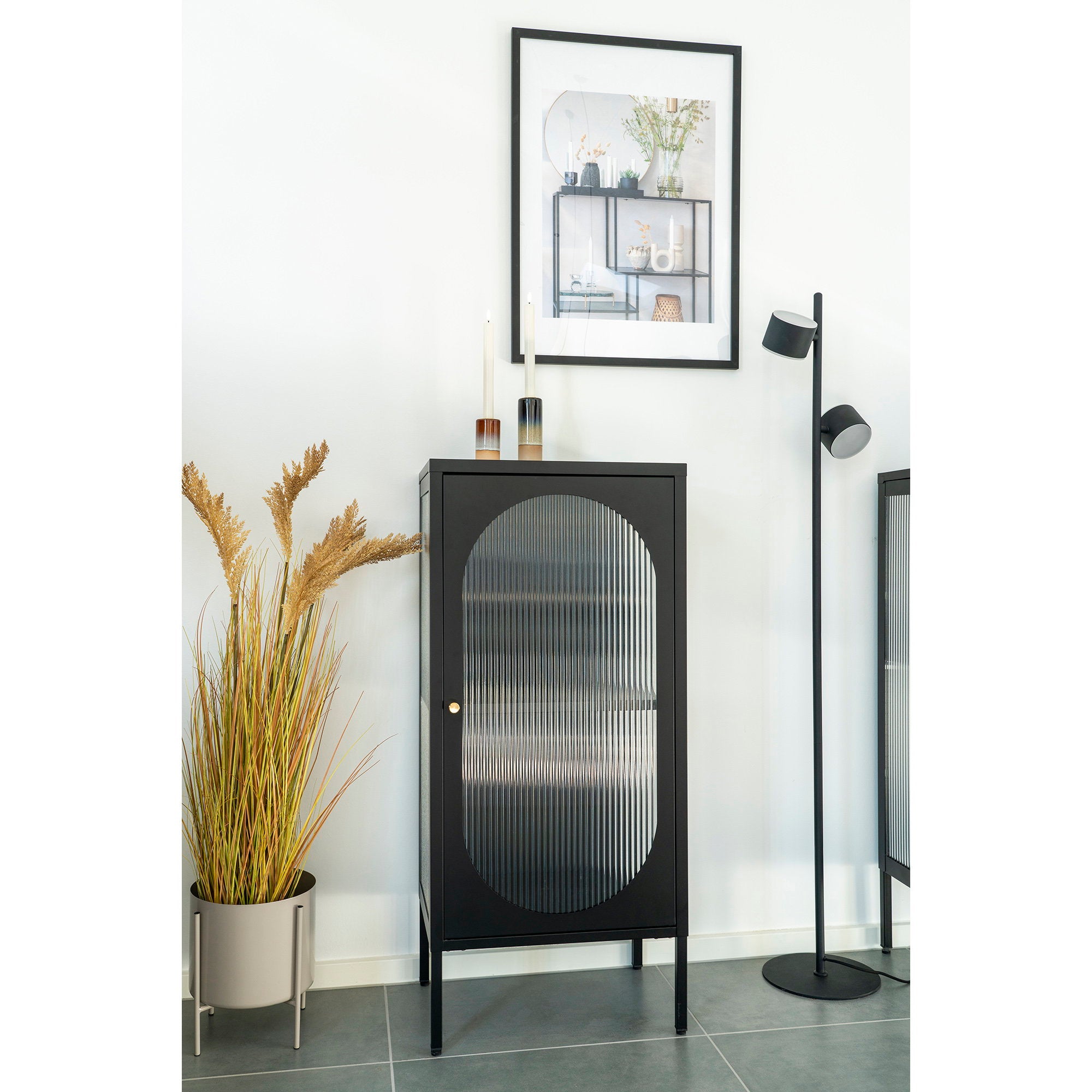 Vitrine Adelaide noire en situation salon blanc herbes séchées lampadaire
